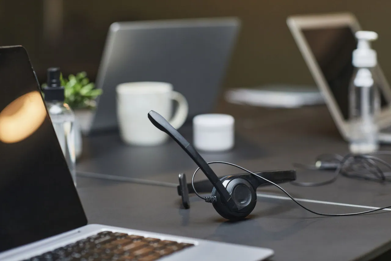 A desk with a laptop and headset, ready to answer support messages